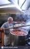 an-italian-man-making-a-huge-pot-of-meatballs-and-sauce-AYCGT1.jpg